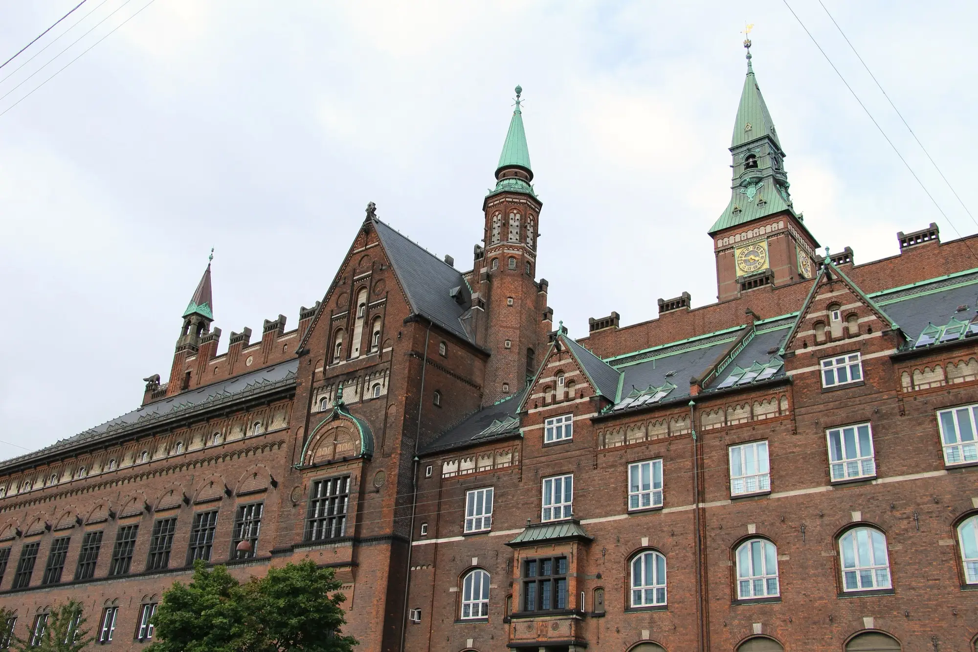The red-brick facade and green towers of Copenhagen City Hall