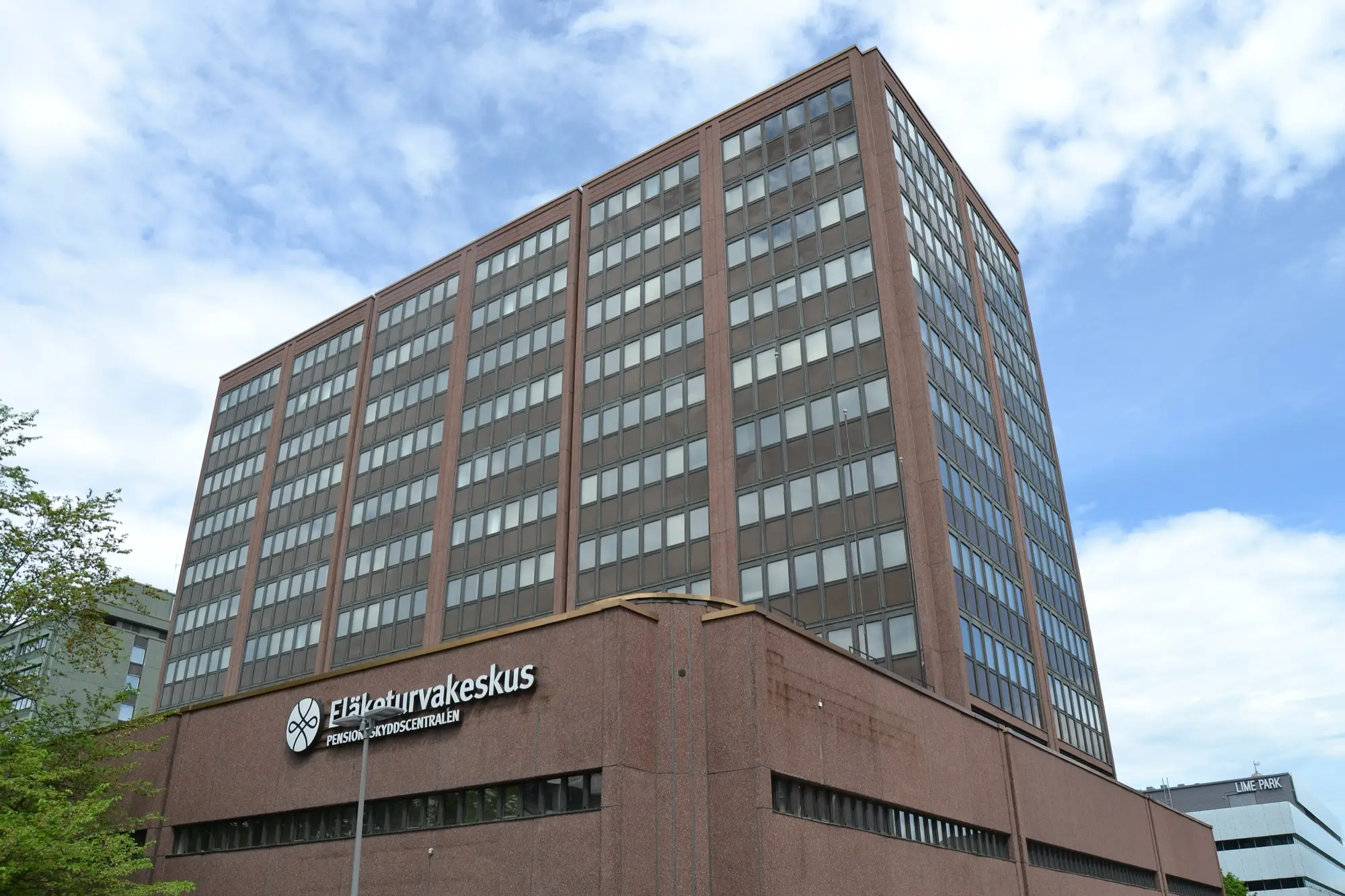 The tall brown office tower of the Finnish Centre for Pensions in Pasila, Helsinki, with the Eläketurvakeskus sign above the entrance.