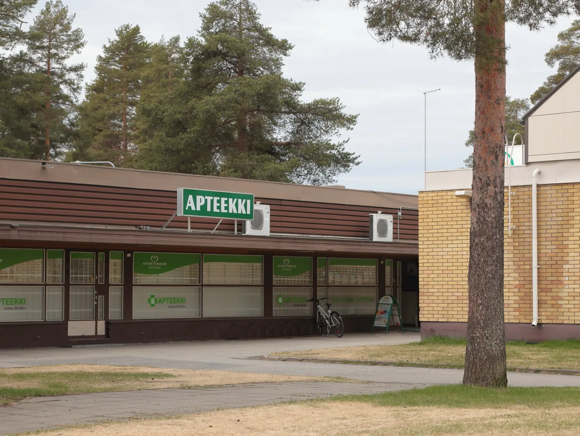 A pharmacy with a green Apteekki sign on a low shopping centre building in Oulu.