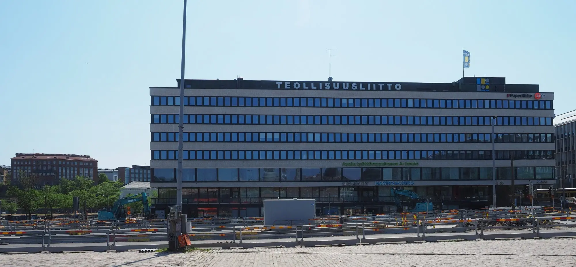 The Teollisuusliitto trade union head office building across a cobbled square in Hakaniemi, Helsinki.